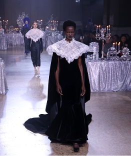 Model walking down runway with black and white dress